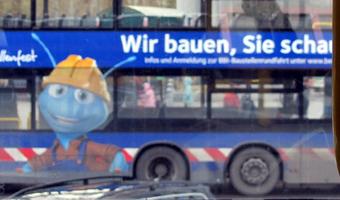 Blue cartoon ant with motto “Wir bauen...Sie schauen”