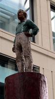 Wooden sculpture of man; mounted at top of large wooden pole.