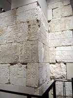 Wall of large white stone with hieroglyphic carvings.