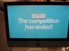 Flat panel screen with words “The competition has ended” and  “application terminated unexpectedly”  dialog