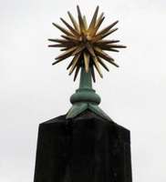 spiky gold star atop an obelisk-like column near river Spree