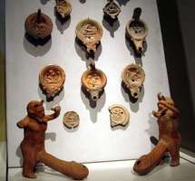 Assortment of Roman oil lamps, two in form of satyrs with immense penises