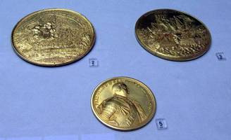 Two gold coins showing “tails” side, one showing head of King Friedrich