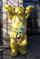 Bear painted yellow, wearing sash reading “Welcome to Berlin”