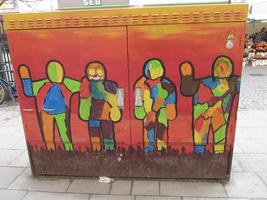 Painted power box with pictures of outline of men filled with multiple colors