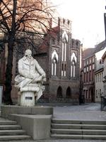Statue of seated man; church in background