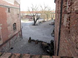 View of fortress courtyard and brick buildings on either side.