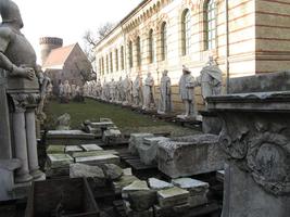Line of statues facing the other set of statues, ruined blocks of marble in foreground