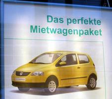 Poster with small yellow car and words “The perfect rental car package”