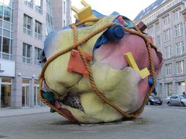 Another area of sculpture by Claes Oldenburg; large ball of burlap with household objects wrapped in rope