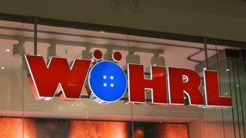 Sign for Wöhrl clothing store; the o part of “ö” is in the shape of a button