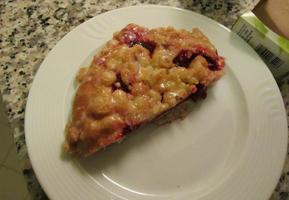 Half of a round streussel pastry with berry filling