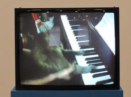 Video screen showing cat “playing” piano