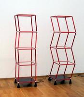 Two sets of four stacked, motorized red wire cubes, undulating left and right