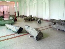Large steles lying on floor; one on a hand-lift