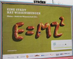 Billboard: “A city has hunger for science”, with E=mc squared spelled out in pretzels
