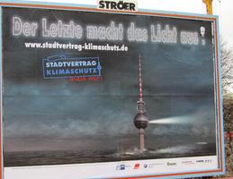 Billboard about climate change; shows Berlin television tower almost totally submerged. Text: “The last one out turn off the light.”