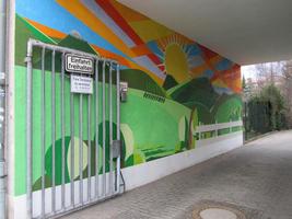 Passageway wall painted with sun, hills, and meadow motif
