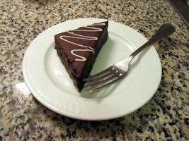 Chocolate covered pastry triangle on plate with fork