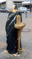 Brass water fountain embedded in black stone sculpture