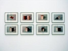 Exhibit of eight photos of geometric shapes made of cardboard