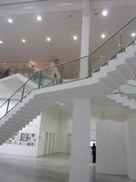Open space in gallery with two staircases criss-crossing in X pattern
