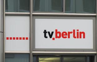 Sign “tv.berlin”; tv in black, .berlin in red. The dot is subscripted.