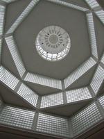 Upward view main hall of museum; light panels in concentric geometric forms offset at odd angles