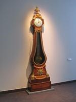 Grandfather clock whose body is roughly the shape of a bass violin