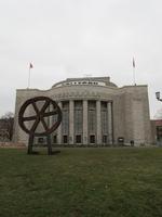 Sculpture of spoked wheel on legs in front of Volksbühne building