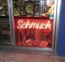 Red neon sign: “Schmuck”