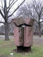 Sculpture of two stone rectangles topped by two irregular cubical stone pieces