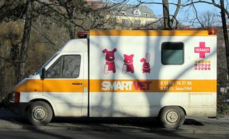 SmartVet veterinarian service ambulance with bandaged cat, dog, and rabbit on sign