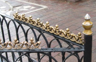 decorative brass metalwork on black iron fence