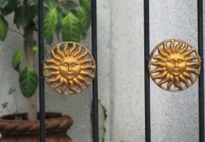 gate with smiling sun metal ornamentation