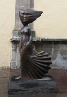 figure with hair and dress blown back by the wind