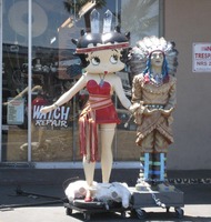 Statue of Betty Boop in Indian headdress, next to statue of a Cigar Store Indian