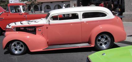 Classic car with salmon colored lower body; white upper body.