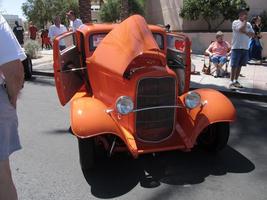 Orange classic car with hood partially up