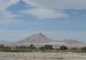 Desertscape with large and small mountain in background.