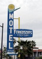 Motel sign for Fergusons Downtown Motel; blue sign with gold circular icon at top and checkmark beneath it.