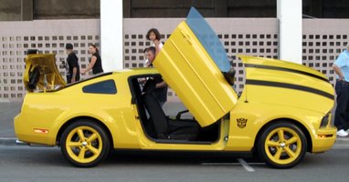 Yellow car with doors, hood, and trunk opening at unusual angles