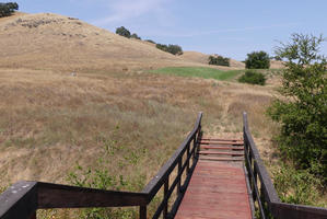 Wooden stairway in foreground; hills in background