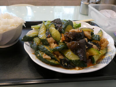 Plate with green vegetables and pork; rice bowl at left