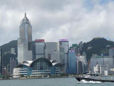 Skyline of Hong Kong in background; boat in foreground.
