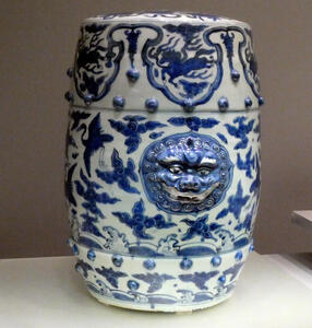 white jar with blue glaze and reliefwork buttons and head of god/demon