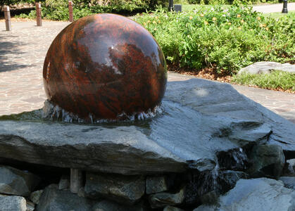 brown stone globe in fountain