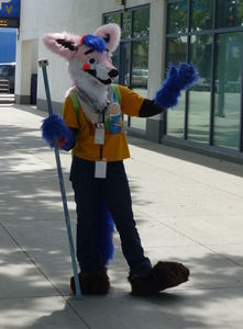 Cosplayer in wolf-like costume with blue arms and legs.