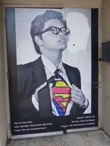 Asian boy opening shirt to reveal superman costume beneath. “The Hero Within” by Neni Silva