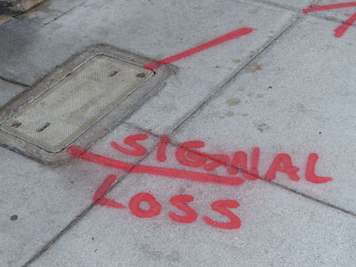 “Signal Loss” painted in red spray paint near utility access